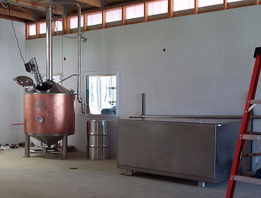 The still and mash tun in the process of being piped up. 